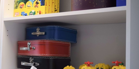 reol med legofigurer og små kufferter