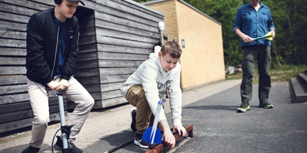 børn eksperimenterer med at affyre en pil fra en hjemmelavet konstruktion